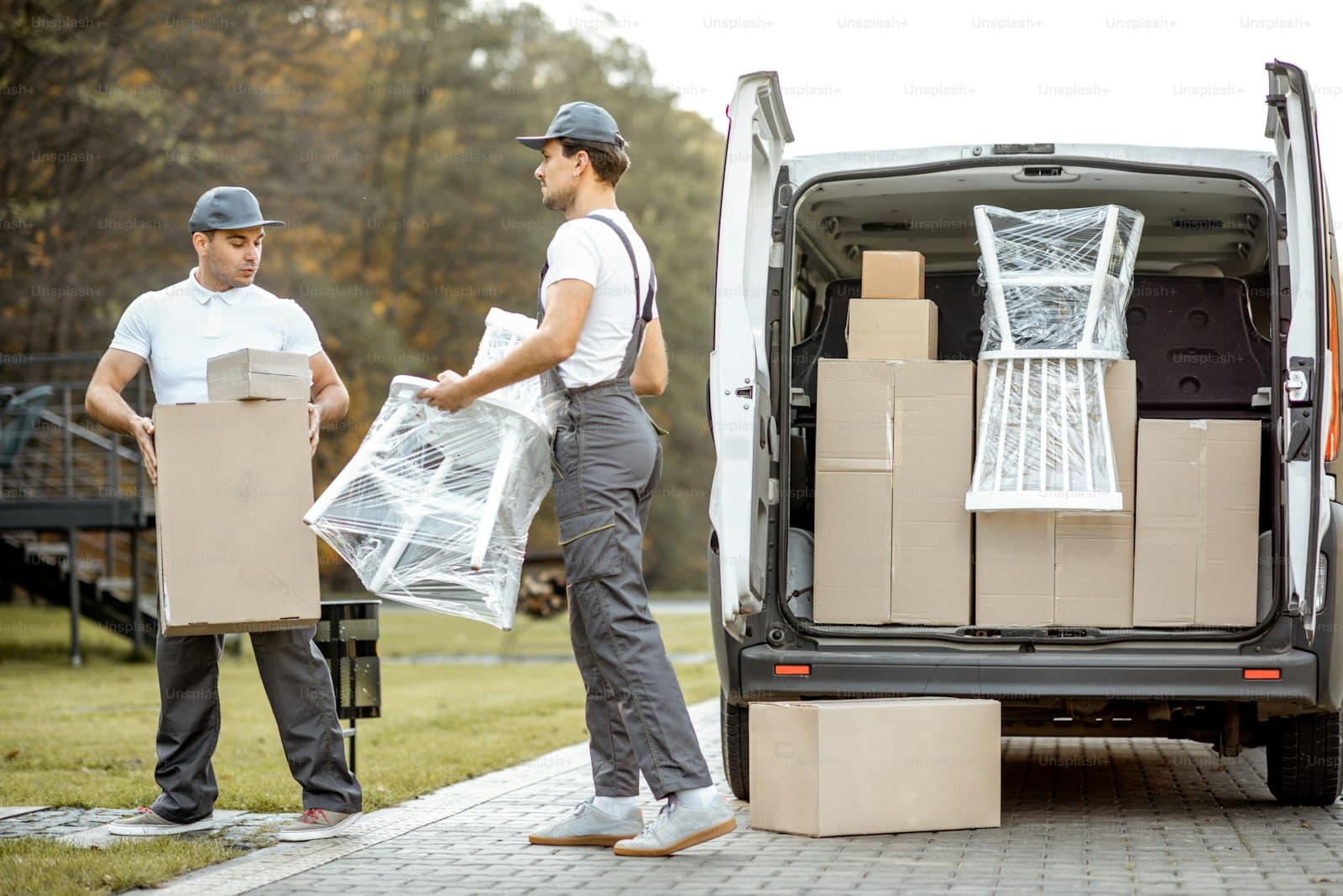 Two professional movers loading boxes into a moving van